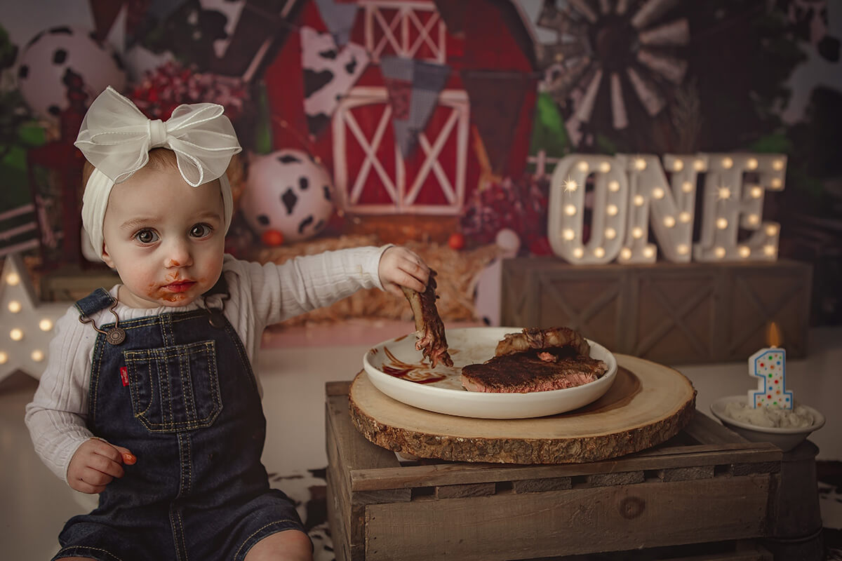A baby girl covered in steak sauce eats a steak for her farm themed birthday after finding her overalls and more baby clothes in springfield il