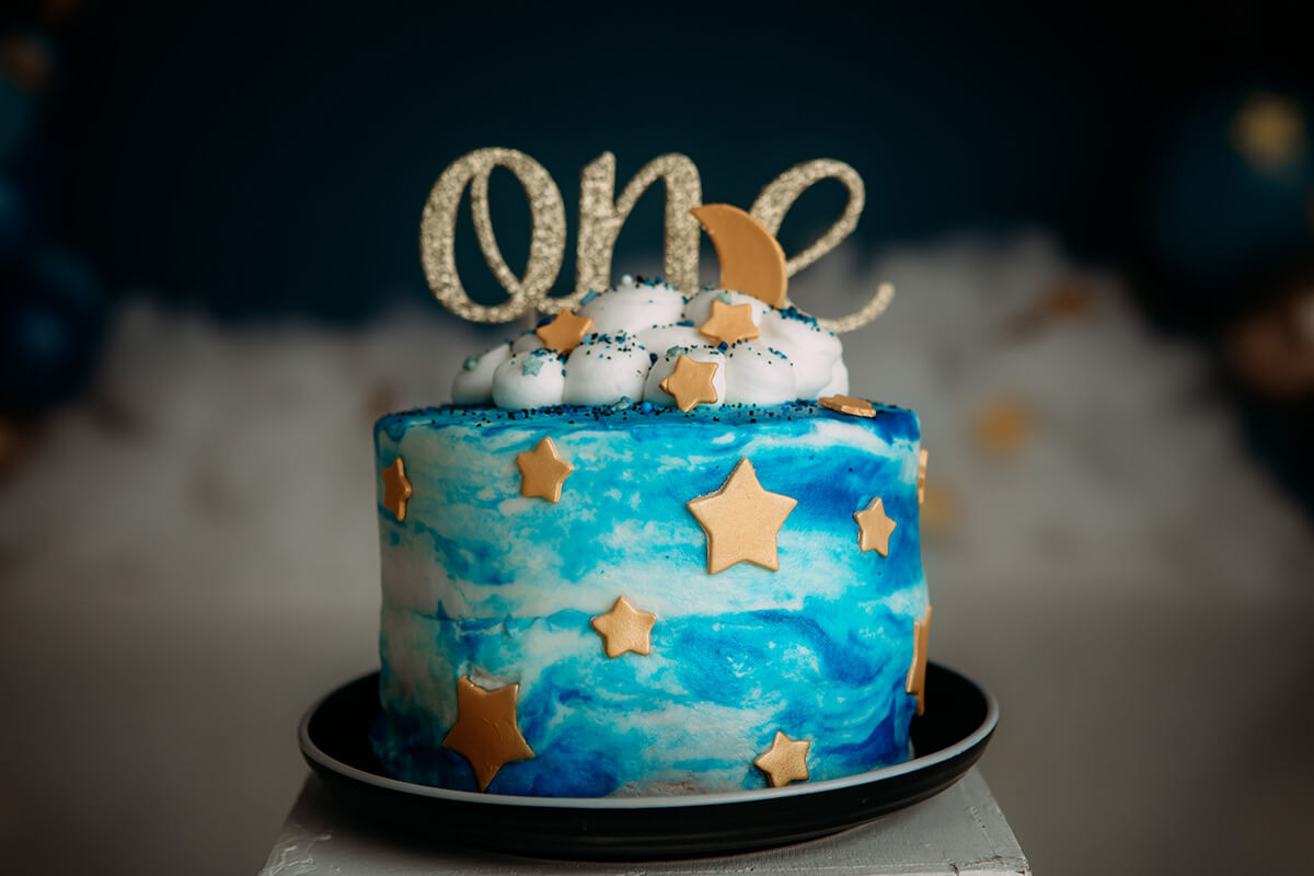 Details of a decorated first birthday cake with stars and blue swirls