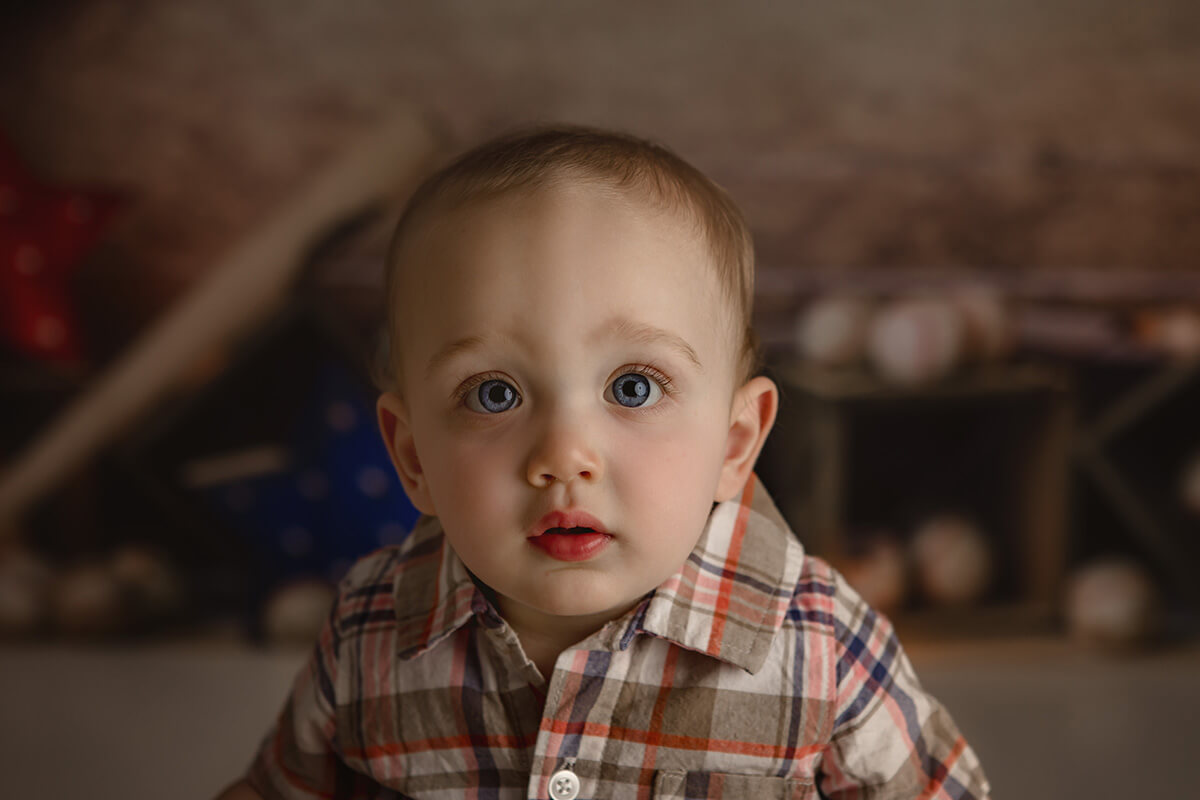 A closeup image of a baby boy in a plaid shirt with big blue eyes before some things to do in springfield il with toddlers