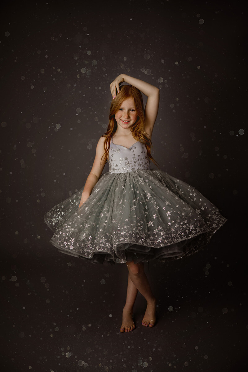 A young girl in a silver star covered dress dances in a studio after visiting preschools in Springfield, IL