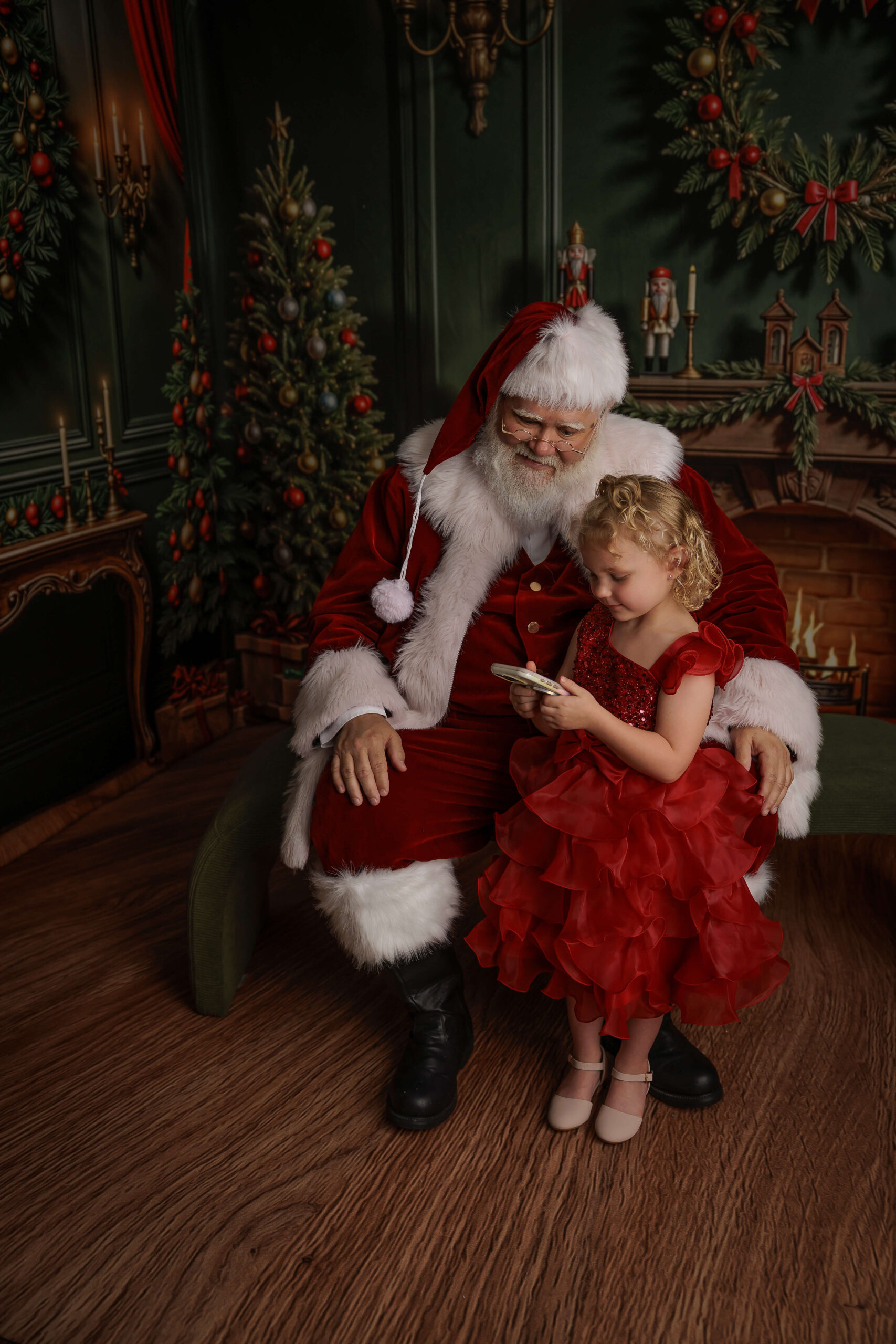 a toddler girl reads a note to santa while standing with him during christmas events in springfield, il