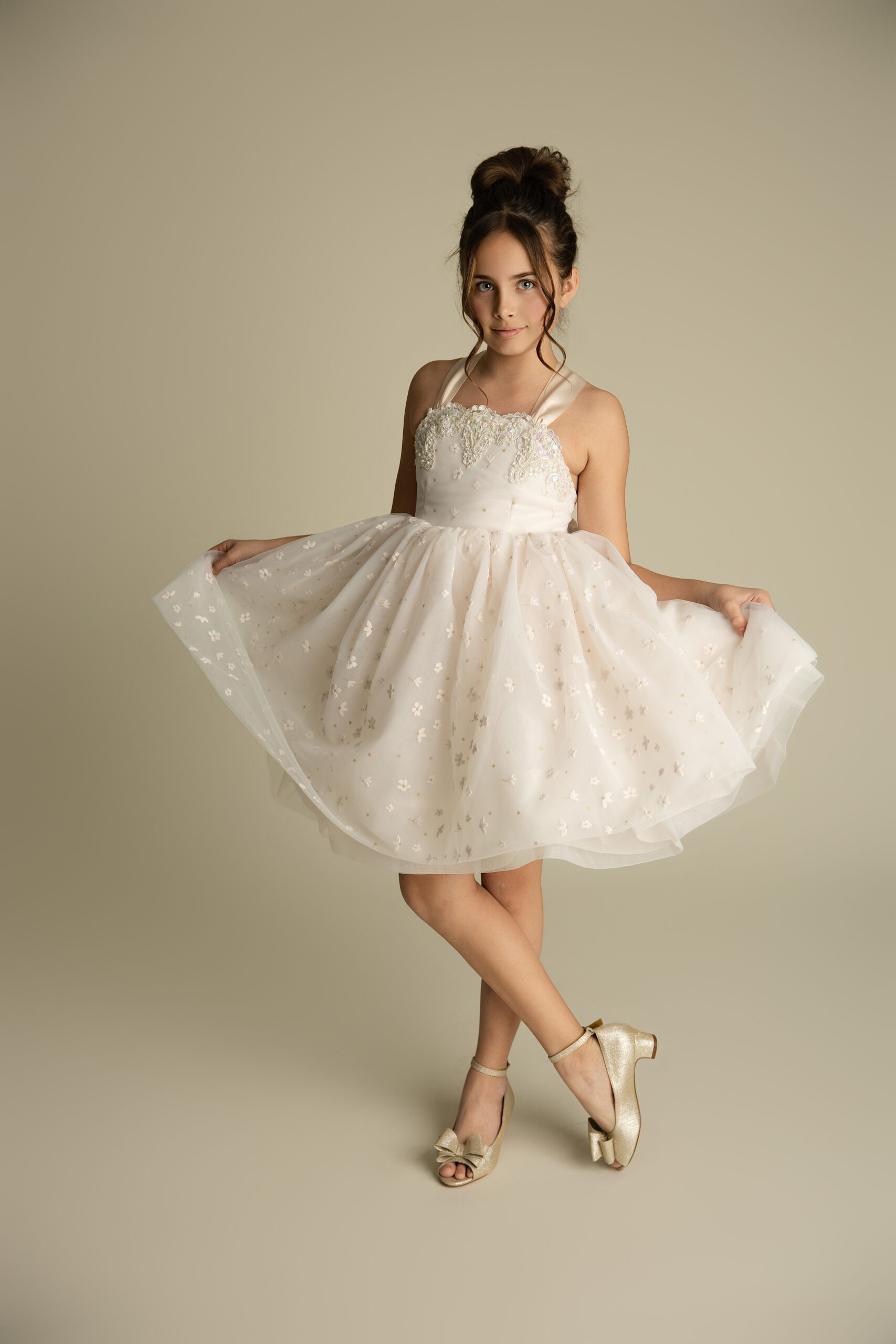 A young girl with dark hair holds her skirt while standing in a studio after finding great kid-friendly restaurants in Bloomington, IL