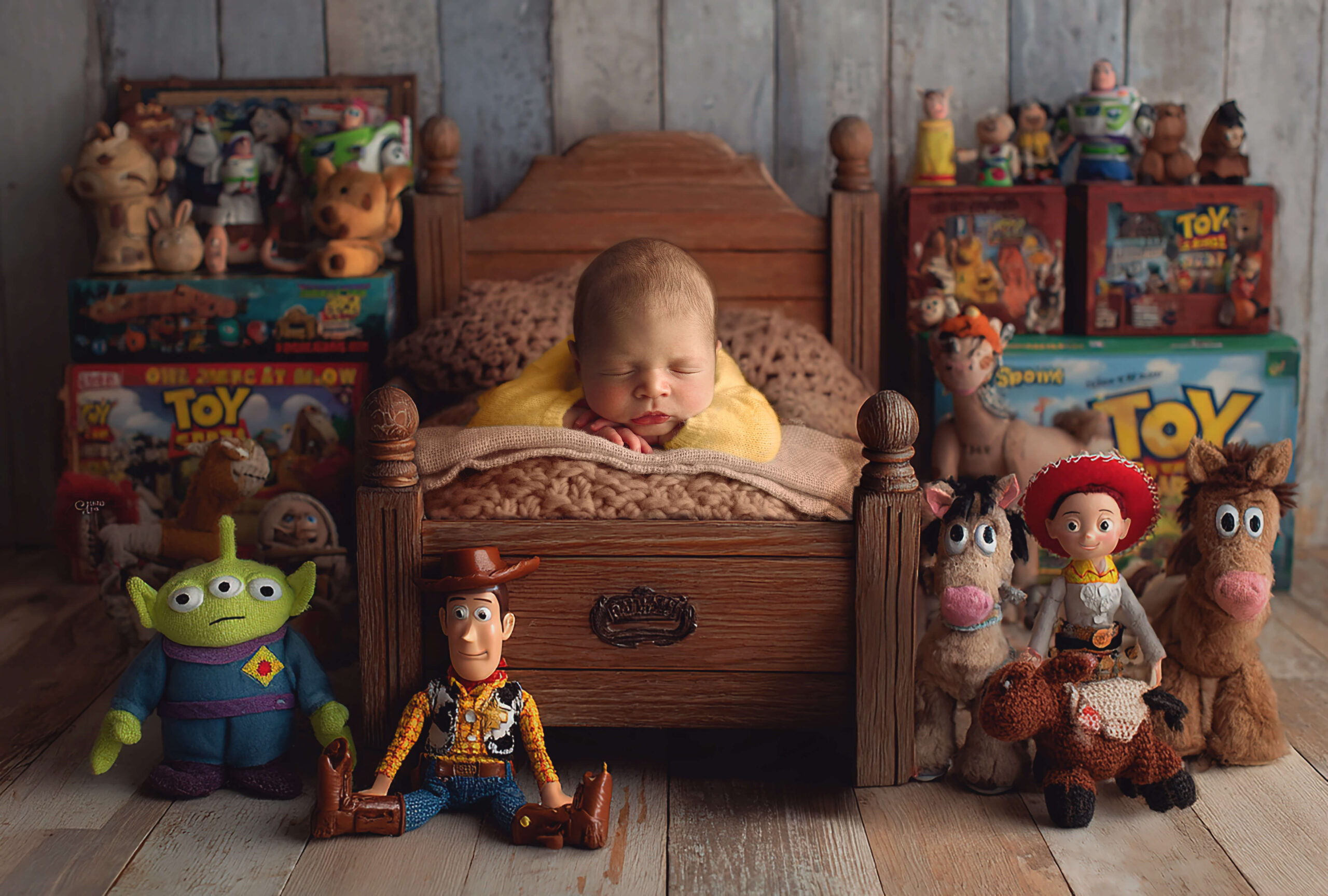 A sleeping newborn baby in a wooden bed surrounded by toy story toys after meeting postpartum doulas in Peoria, IL